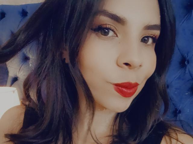 VioletaStone heeft donkerbruin haar, rode lippenstift en dikke eyeliner. Haar neus is klein, en ze glimlacht lichtjes met een schattig gezicht. Haar borsten zijn niet zichtbaar..
