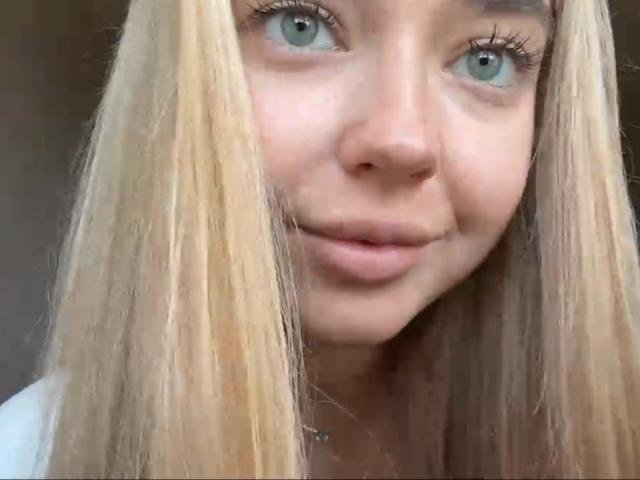 Georgine Branen, con cabello rubio, ojos azules y una ligera sonrisa, mostrando su rostro y labios, mirando hacia arriba con largas pestañas, en una foto similar a un selfie..
