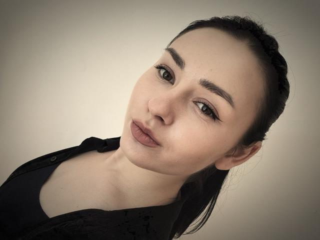 OnitaWaltemath tiene labios carnosos, cejas oscuras y una ligera sonrisa. Lleva una camisa negra, y su cabello oscuro está trenzado. Sus ojos miran hacia adelante..