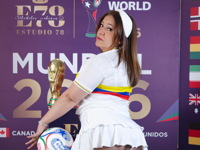 Jade, la più attraente, con capelli castani, cappello bianco, vestito bianco, che tiene un trofeo, in piedi, che guarda indietro, che tiene un pallone da calcio, sfondo viola, vestito a righe bianche e gialle, carina, attraente, con il seno visibile..