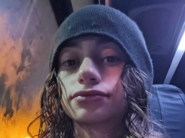 O rosto de KatalinaLaurent, usando um gorro verde, com cabelo castanho molhado, um leve sorriso e pele clara, em um ambiente com pouca luz e onde ela veste uma camisa azul..