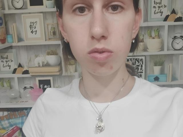 Christen Tornatore, com pele clara, olhos castanhos e lábios carnudos, vestindo uma camisa branca e um colar de prata com um pingente redondo, tem pequenas espinhas na bochecha esquerda..