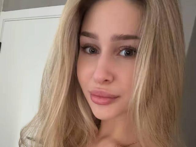 Milagros Edmisten ha i capelli biondi, gli occhi azzurri e le labbra rosa. Il suo seno è leggermente visibile sotto la maglietta. Sta sorridendo in modo sottile e seducente nella foto..