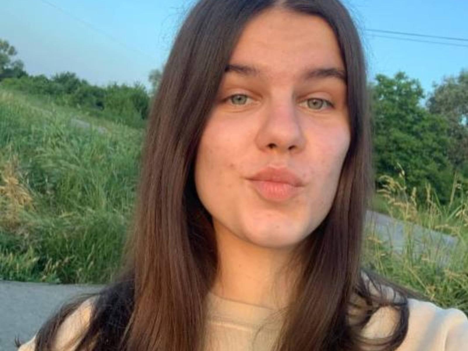 DiamondDvorsky heeft volle lippen, lang bruin haar, groene ogen en een lichte huidskleur. Ze maakt een fronsende gezichtsuitdrukking met licht samengeknepen lippen. Ze draagt een witte blouse..