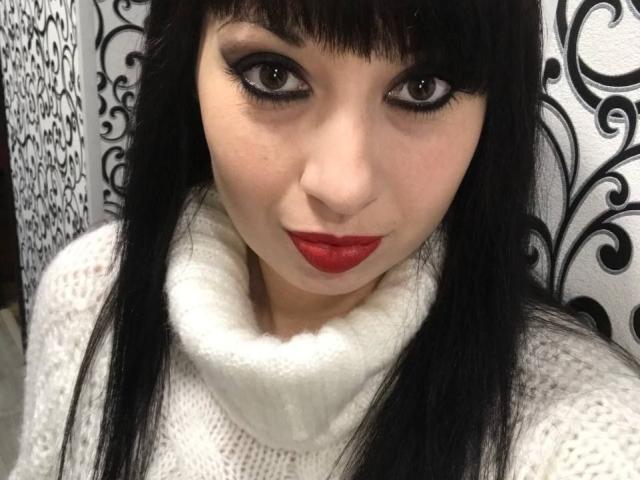 LangoriaJoy a les cheveux noirs, du rouge à lèvres, et porte un pull blanc à col roulé. Elle a de grands yeux marron avec un trait d'eye-liner noir épais, et une expression faciale mignonne et confiante..