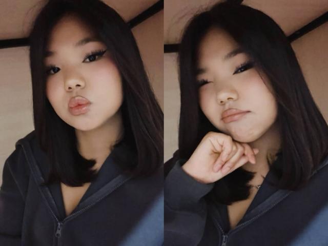 EllaBadgero, avec des cheveux noirs, portant une veste à capuche zippée sombre, lèvres boudeuses sur l'image de gauche, clignant de l'œil avec la main près du menton sur l'image de droite. Visage asiatique doux et mignon..