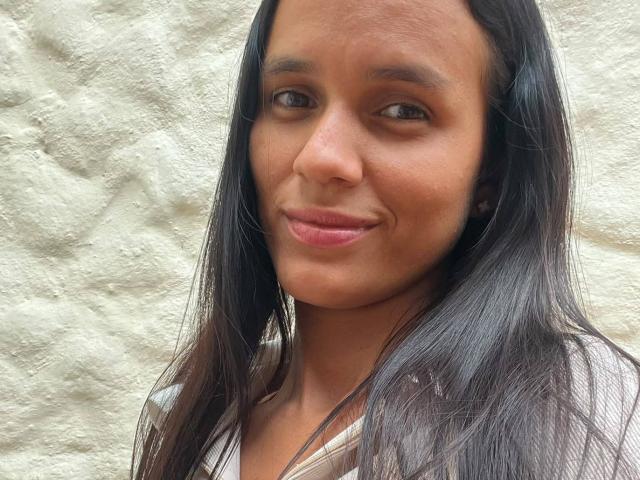 LaBandy a une peau marron clair, de longs cheveux noirs et lisses, et elle sourit avec des lèvres roses. Elle porte un haut blanc qui révèle ses petites seins. Ses fesses ne sont pas visibles..