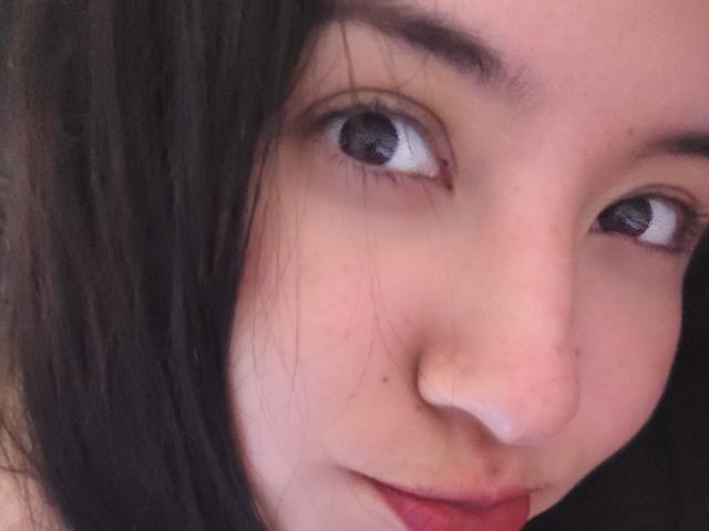 Het gezicht van SusanMonroy, met haar bruine ogen die iets omhoog kijken, donker recht haar, lichte huid en een subtiele glimlach. Haar neus is klein en haar lippen zijn lichtjes open..