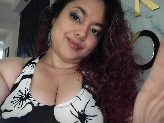 LarussoSophi ha i capelli ricci, di un colore rosso-marrone, una carnagione media e un sorriso che mostra un rossetto rosa. Indossa un top a halter nero e bianco con un motivo floreale, che mette in mostra il suo seno abbondante..