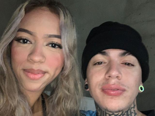 NickySixNine con cabello rubio y maquillaje, y NickySixNine con un gorro negro, aretes verdes y tatuajes, ambos sonriendo a la cámara..