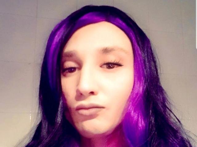 MaryXXL-hot hat lila und schwarzes Haar, braune Augen und einen neutralen Gesichtsausdruck. Ihr Gesicht ist im Bild zentriert, und sie hat einen hellen Hautton..