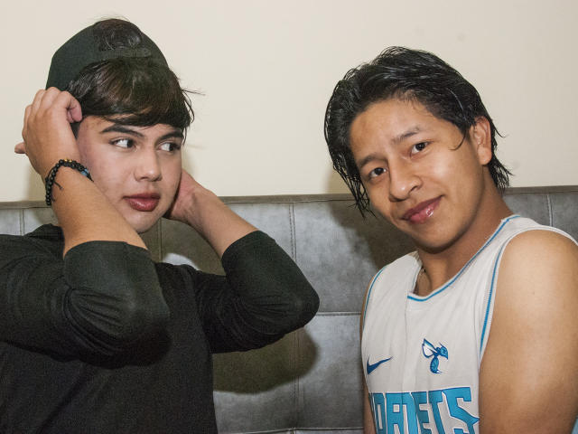 HornyMaleTwaylight in a black shirt with hands on head, looking sideways. HornyMaleTwaylight in a white basketball jersey, smiling. Both have Asian features and black hair.