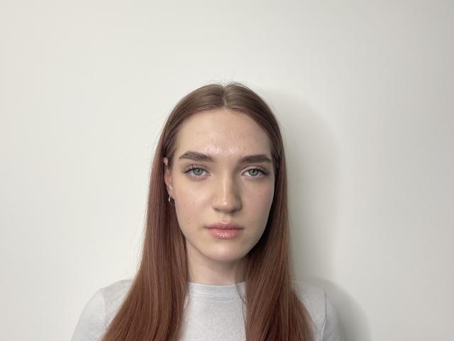Lavern Fernald heeft lang, recht bruin haar, een lichte huid, blauwe ogen en draagt een grijze trui. Haar lippen zijn lichtroze en ze kijkt recht in de camera..