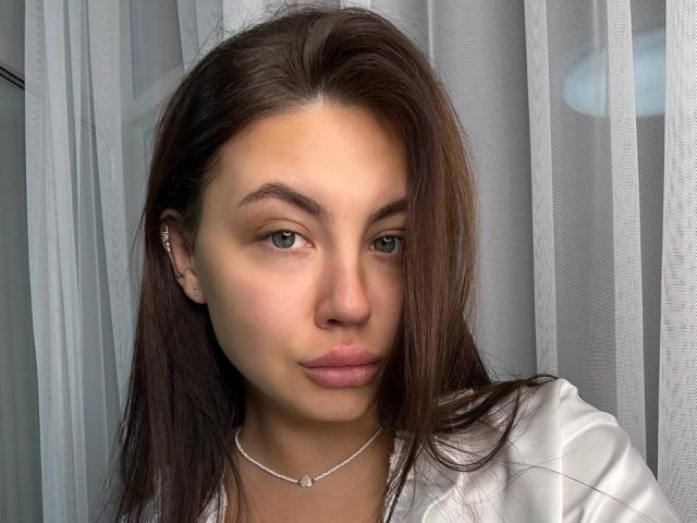 Ines Gueningsman ha i capelli castani, gli occhi verdi e un piccolo piercing al naso. Indossa una collana d'argento e una camicia bianca, appare seria con le labbra leggermente dischiuse..