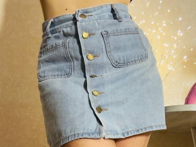 La gonna di jeans di BalletSwan, chiusa sul davanti con bottoni dorati, presenta due tasche e si posiziona appena sopra i glutei. La gonna è di un azzurro chiaro con una leggera sfumatura..