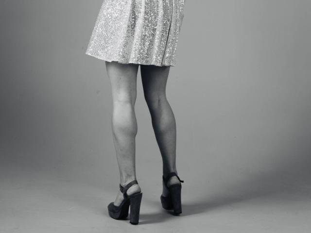 La jupe argentée scintillante de BalletSwan, qui laisse entrevoir ses jambes nues, et qu'elle porte avec des chaussures plates noires à talons hauts, avec ses fesses légèrement visibles par derrière..