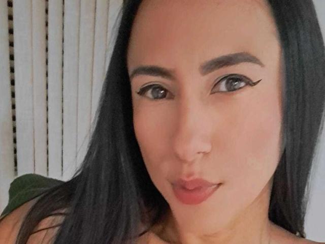 JadeFoster has black eyeliner wings, a cute pout, and a small nose. She's a cute Asian woman with long black hair and a slight smile.