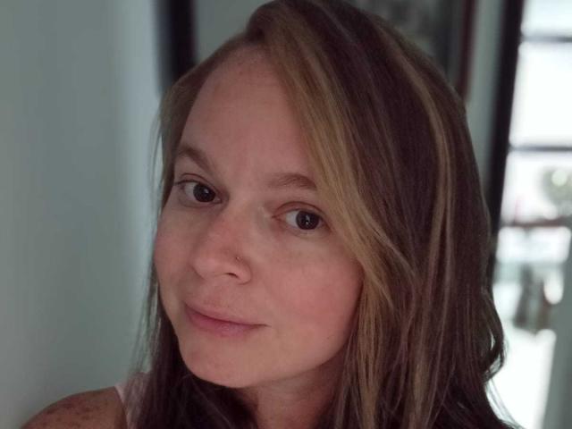 PamelaColin has light brown hair with blonde highlights, a small nose ring, and a subtle smile. She's looking at the camera with brown eyes.