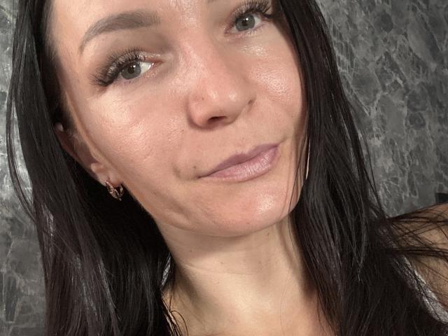 En un selfie, se ve el rostro de Adelaide Lisa, mostrando su piel brillante, su cabello negro y lacio, sus ojos verde claro y una sonrisa sutil con sus labios rosados. Lleva pequeños aros..
