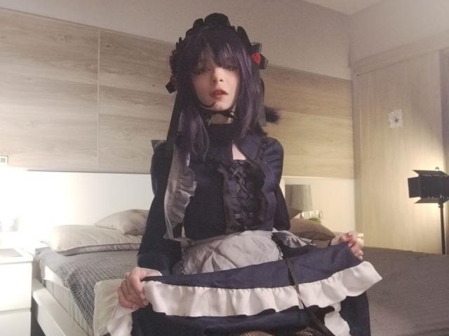 ChangCaddle with dark purple hair, wearing a black and white maid outfit, holding the skirt up, showing a frilly underlayer, standing in a bedroom, looking at the camera.
