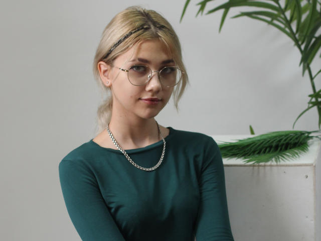 DataSley ha i capelli biondi, porta gli occhiali e indossa una maglia verde a maniche lunghe con una collana a catena d'argento, mostrando un leggero sorriso. Ha il seno piccolo ed è molto carina..