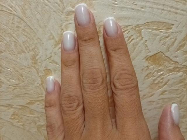ViktoriiaLu's hand with shiny, white-painted fingernails, showing off neatly trimmed, slightly curved, medium-brown, textured fingers. Boobs not visible. Ass not visible. Tits not visible. Pussy not visible.