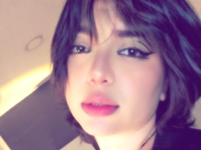 AnnieUwU has dark brown hair, black eyeliner, pink lipstick, and a slightly parted pink mouth, looking directly at the camera with a soft, somewhat seductive expression.