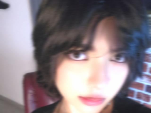 AnnieUwU has short, messy black hair, large brown eyes, and pinkish-red lips. She's blurry, with a soft, almost ghostly face. Her tits are small, barely visible.