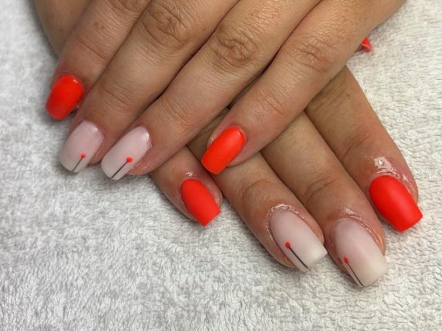 AmmaFrancaises Hände mit leuchtend roten, matten, eckigen Nägeln und rosa, glänzenden, eckigen Nägeln mit roten Punkten auf jedem Nagel. Ihre Nägel liegen auf einem weißen Handtuch..
