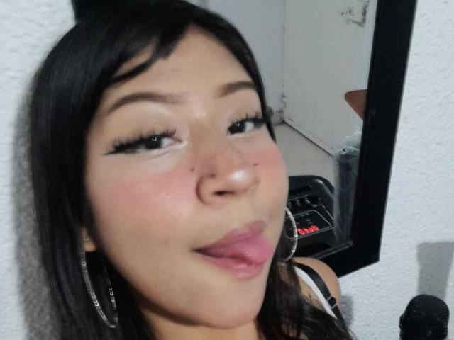 BonnieBodn heeft een lichtbruine huid, zwart haar en steekt haar tong uit. Ze draagt zwarte eyeliner en grote oorringen, met een lichte blush op haar wangen..