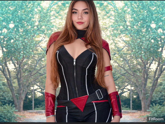 SofieWhite has long brown hair, wearing a black and red corset with zippers, red gloves, and a belt, standing in front of a tree-filled background. She has small tits.