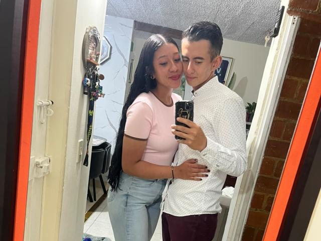 LiaMarek with long black hair, pink top, and blue jeans stands next to LiaMarek with short brown hair, white polka dot shirt, and maroon pants in a mirror selfie.