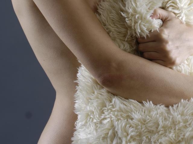 KamiLove's arm wrapped in a fluffy white blanket, showing a soft, pale skin texture with a subtle red mark on the inner arm, close-up shot.