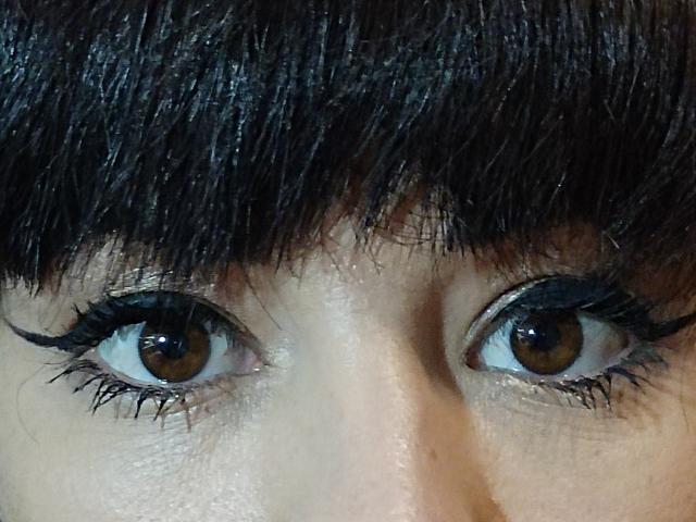 OrianaLaFrancaise's brown eyes with thick black eyelashes, looking intensely forward, her dark brown eyebrows slightly raised, and her fair skin showing subtle texture.