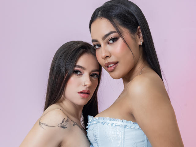 PaolaYKatty, met donker haar, lichte huid en een tatoeage, draagt een blauwe jurk zonder bandjes, naast een jongere PaolaYKatty met vergelijkbare kenmerken en make-up..