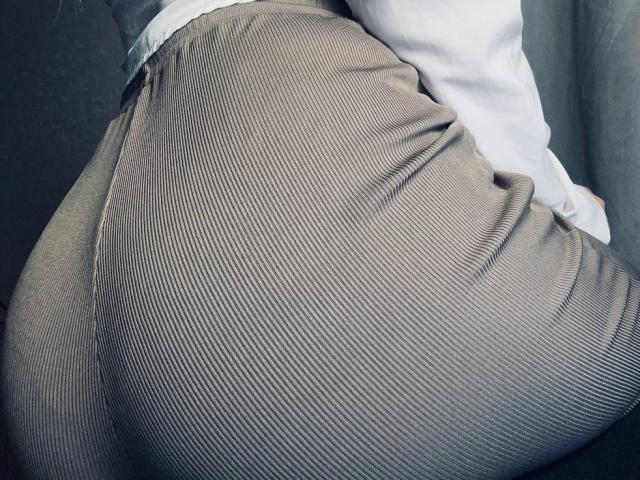 BalletSwan's ass in tight, ribbed, gray pants, slightly bent over, showing the curve of her butt and the texture of the fabric. Her white shirt is partially visible.