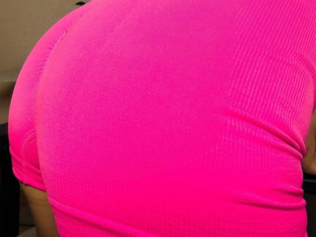 Il sedere rosa acceso di BalletSwan, in una maglietta aderente a coste, a maniche corte, che mette in risalto le curve e presenta una leggera piega sul lato destro. L'immagine si concentra sulla parte bassa della schiena..