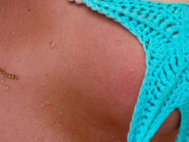 ChristieGarci's wet, tan, and glistening ass in bright turquoise crochet bikini bottom with a small gold belly button ring, showing water droplets on her skin.