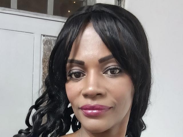 AliciaPussie tiene un cabello negro y brillante, con ondas, cejas oscuras, ojos grises y labios rosados y brillantes. Su piel marrón lisa está resaltada por un maquillaje sutil..