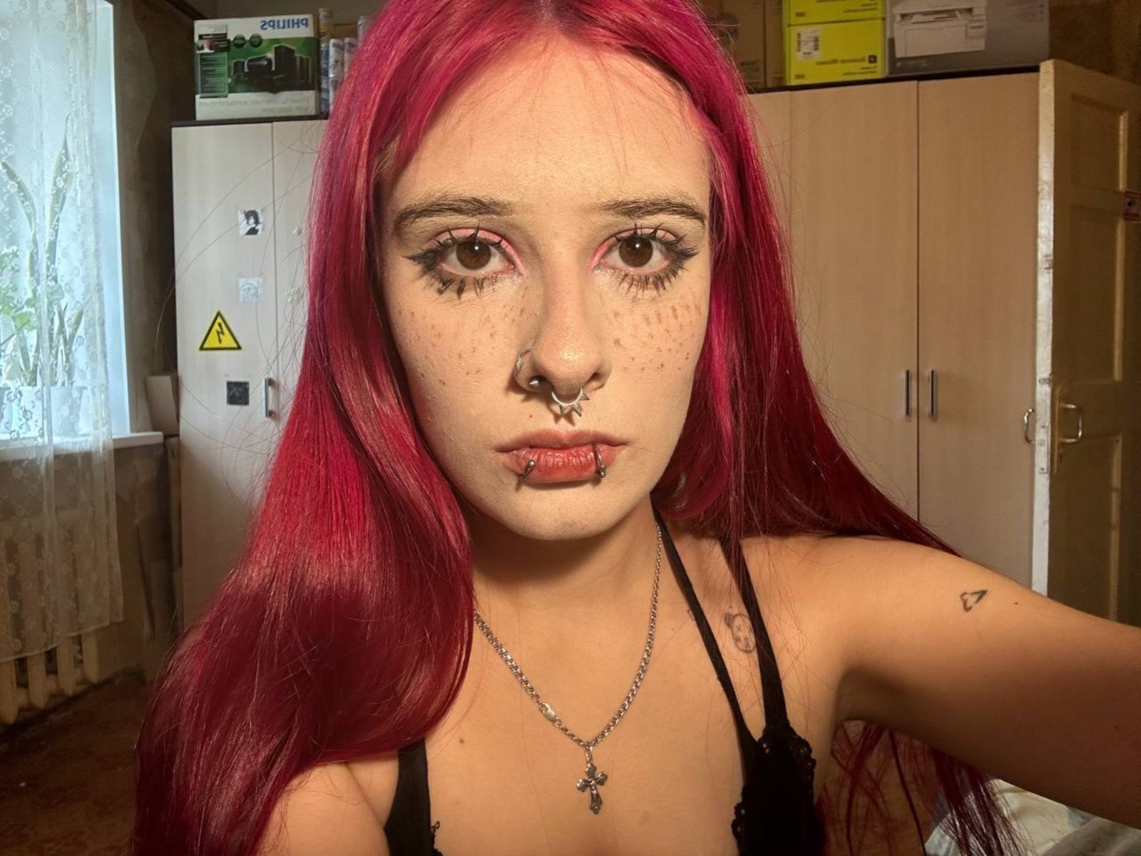 Eugenia Gutterman a les cheveux roux, des taches de rousseur, un anneau au nez, un piercing aux lèvres, du crayon noir pour les yeux et un collier avec une croix. Elle porte un haut noir qui dévoile sa poitrine et a un petit tatouage en forme de triangle..