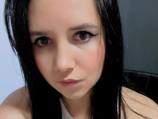 Kkatalina has light skin, black wet hair, and is looking at the camera with black eyeliner, pink lips, and a neutral expression. Boobs visible but not detailed.