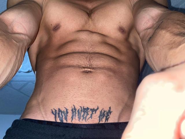 NoahhJacobs muskulöse, tätowierte, gebräunte Bauchmuskeln mit deutlichen Konturen, ein schwarzes Tattoo direkt über der schwarzen Unterwäsche und sichtbare Brusthaare, aufgenommen in einem leicht schrägen, von oben aufgenommenen Selfie..