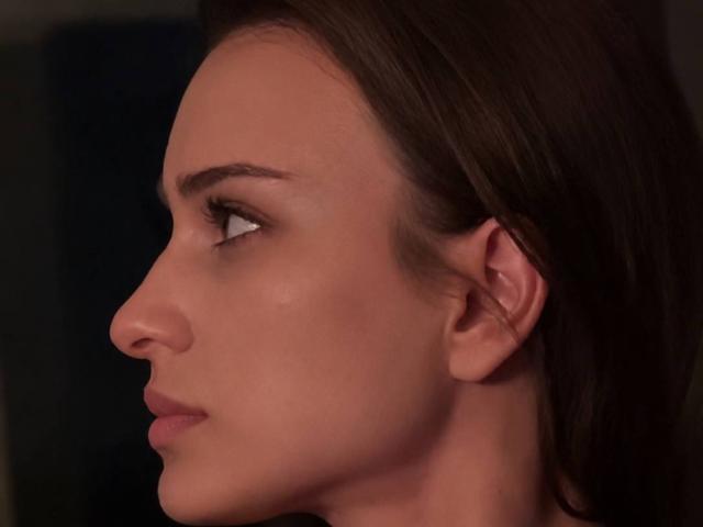 EleanorEvanchyk's side profile shows her brown eyes, slightly parted lips, and smooth fair skin. Her dark brown hair is pulled back, highlighting her elegant nose and small ears.