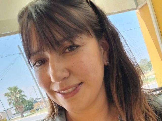 RoxanneBlair a les cheveux bruns avec une frange, des yeux marron clair et un sourire discret. Elle porte de petites boucles d'oreilles et a quelques taches de rousseur sur le visage. Ses fesses ne sont pas visibles..