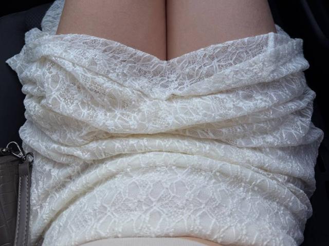 Teffi's white lace dress is wrapped tightly around her cleavage, showing her pale skin and the fabric's intricate, textured pattern. Her chest is prominent, pressed together.
