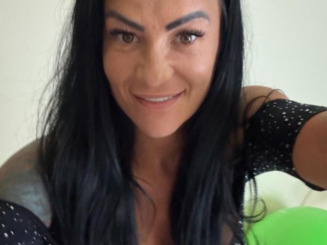 AndraD a de longs cheveux noirs, des yeux marron et un léger sourire. Elle porte un haut noir à pois, qui révèle ses petites seins. Son tatouage est partiellement visible sur son épaule..