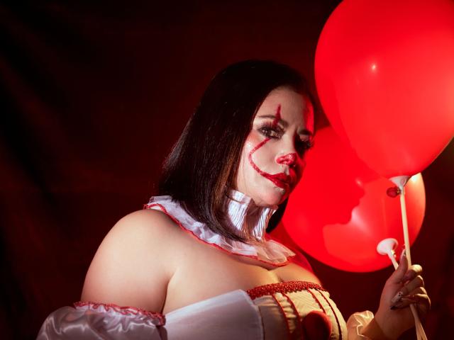 SamanthaVenus with dark hair, bloody face, white ruffled top, holding red balloons, showcasing her large tits, red lipstick, and a sexy, Halloween-themed look.