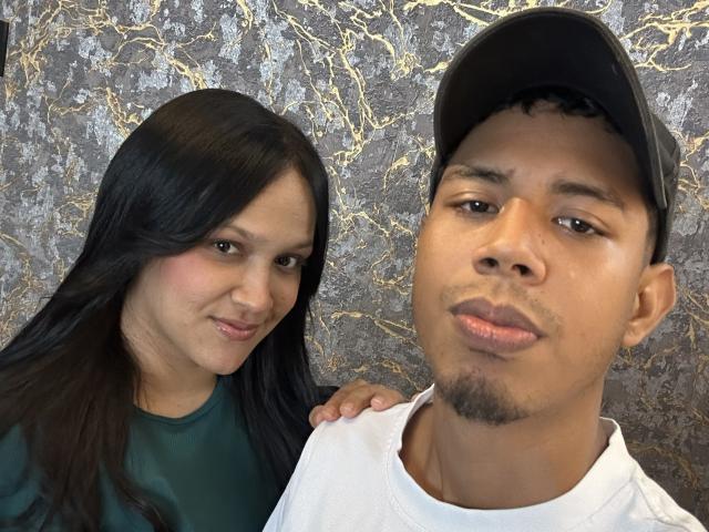 SofiaAndAndres has long black hair, wearing a green shirt, with hand on Andres's shoulder. Andres has a black cap, white shirt, and a goatee, with a pensive look.