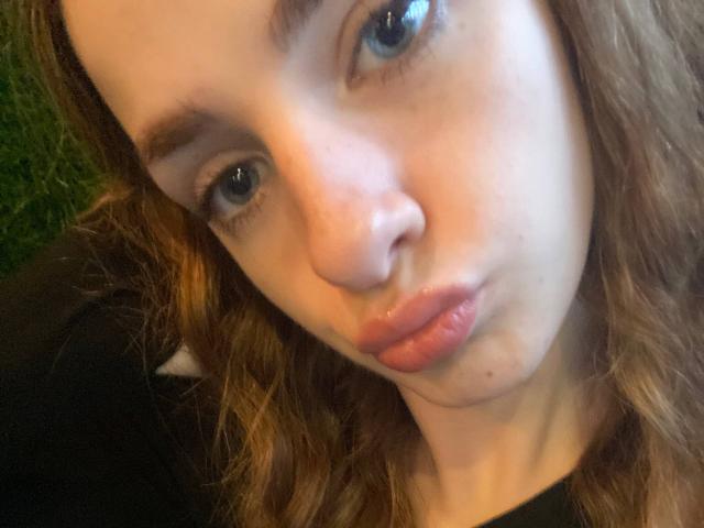 MarcelleMantz's pouty lips are slightly glossy, her blue eyes are looking up, and she's making a silly face with her nose slightly upturned. She has wavy brown hair.
