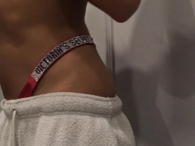 Fridaa's slim, tan midriff with a red thong featuring a sparkly pink band, and white fluffy pants. Her small, firm ass is partially visible.